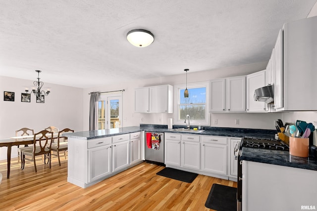 kitchen with white cabinetry, appliances with stainless steel finishes, decorative light fixtures, and sink