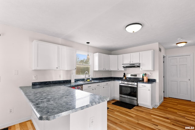 kitchen with sink, white cabinets, stainless steel range with gas stovetop, and kitchen peninsula