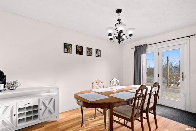 dining space featuring an inviting chandelier and light hardwood / wood-style floors