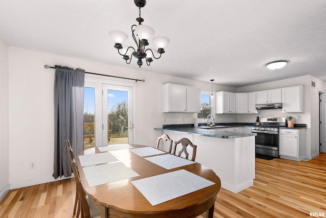 dining space featuring an inviting chandelier, sink, and light hardwood / wood-style flooring