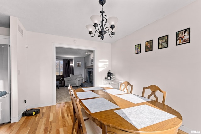 dining room featuring an inviting chandelier and light hardwood / wood-style flooring