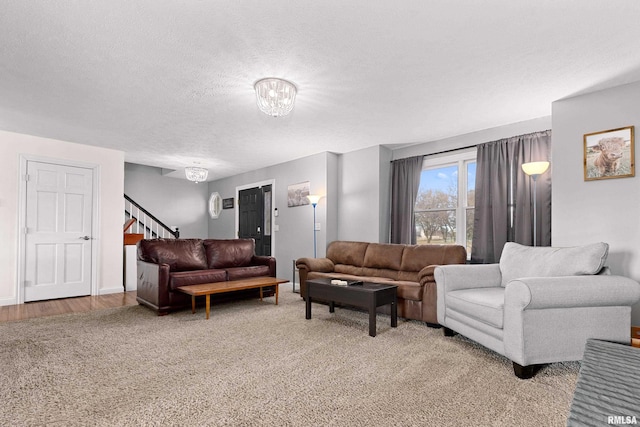 living room with an inviting chandelier, light carpet, and a textured ceiling