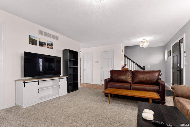 living room with carpet flooring, a chandelier, and a textured ceiling