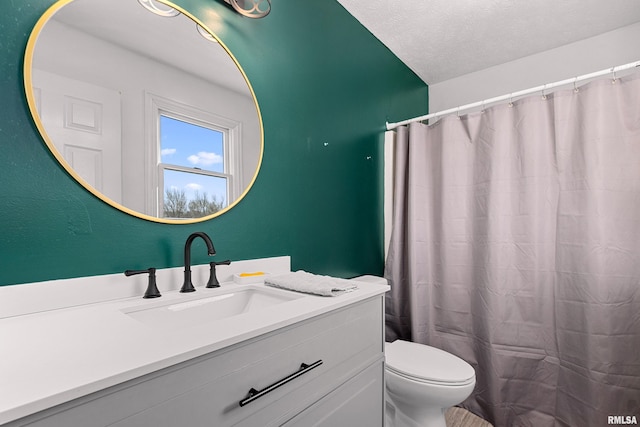 bathroom with vanity, a textured ceiling, and toilet