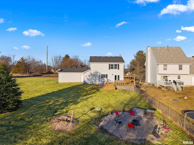 back of property with a wooden deck, a yard, and a patio area