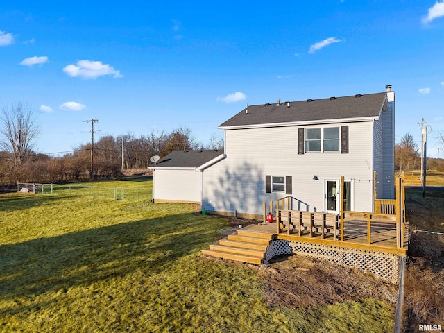 back of property with a wooden deck and a lawn