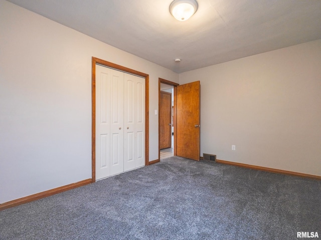 unfurnished bedroom featuring a closet and dark colored carpet