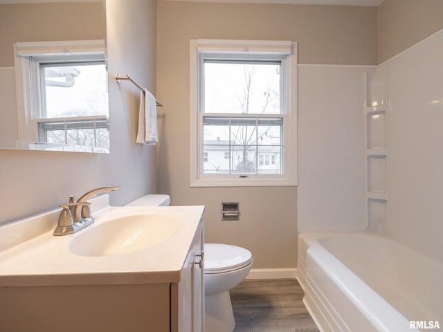 bathroom featuring hardwood / wood-style flooring, toilet, a wealth of natural light, and vanity