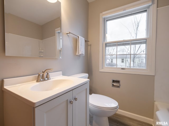 bathroom with toilet, vanity, and hardwood / wood-style floors