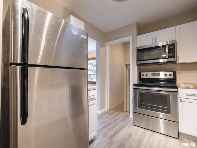 kitchen with white cabinets, light hardwood / wood-style flooring, and stainless steel appliances