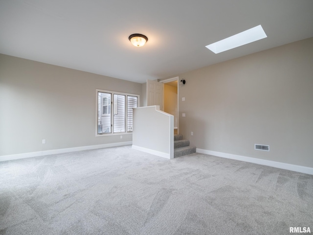 empty room featuring carpet flooring and a skylight