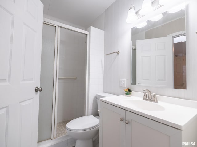 bathroom with vanity, toilet, and a shower with door