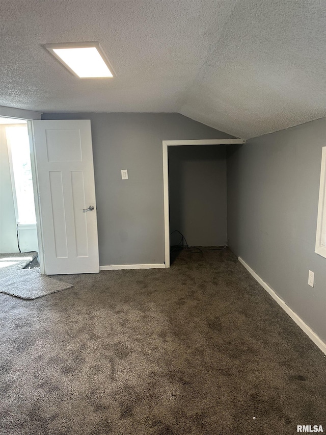 1822 N Sheridan Rd, Peoria, IL 61604 - spare room featuring a textured ceiling, carpet flooring, vaulted ceiling, and baseboards