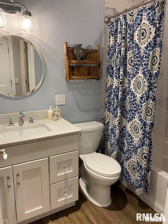 full bathroom with shower / bathtub combination with curtain, vanity, toilet, and hardwood / wood-style floors