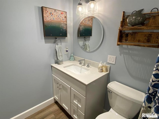 bathroom featuring vanity, wood-type flooring, and toilet