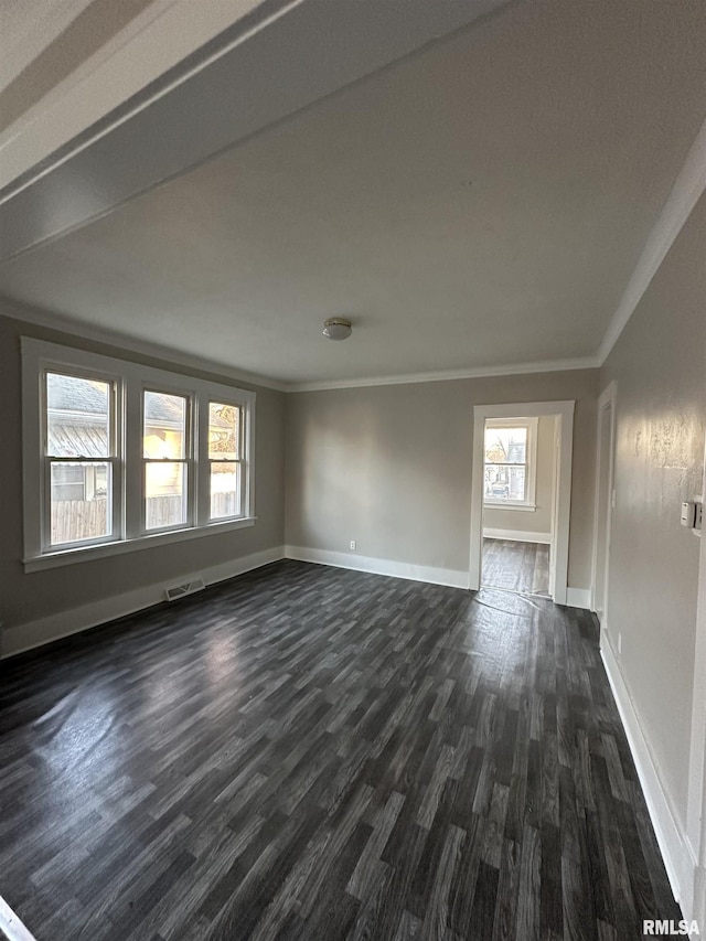 empty room with ornamental molding and dark hardwood / wood-style flooring