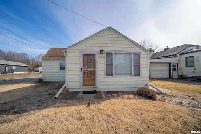 bungalow with a garage and a front lawn