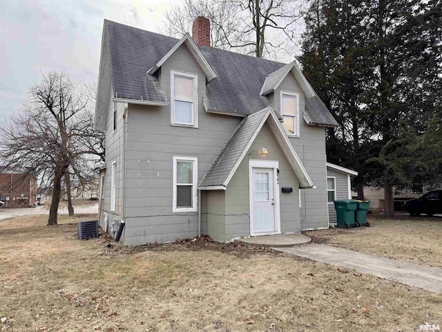 view of front of property with central AC and a front yard