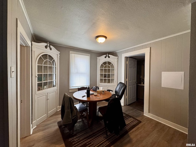 dining room with crown molding, dark hardwood / wood-style floors, and a textured ceiling