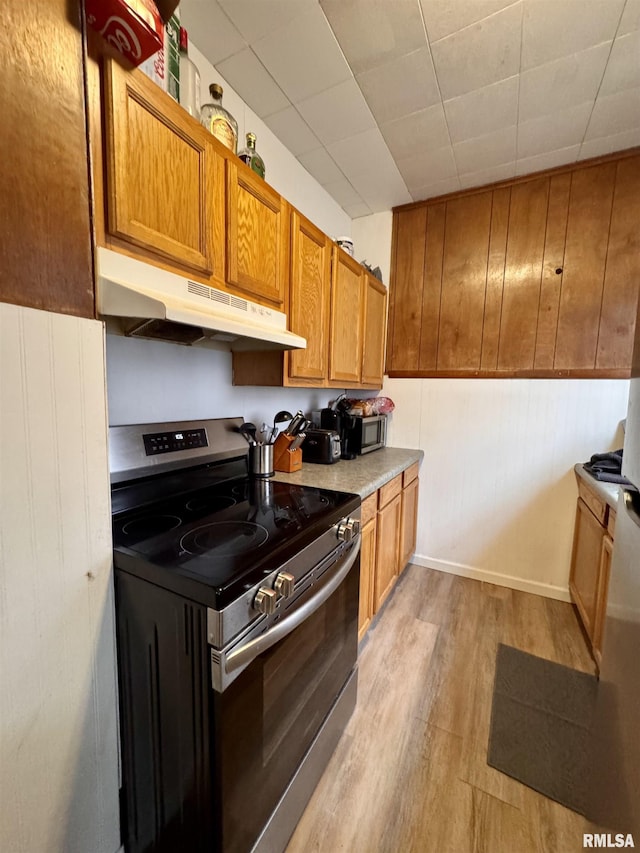 kitchen with light hardwood / wood-style floors and appliances with stainless steel finishes