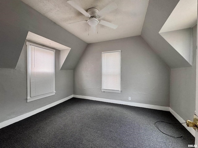 bonus room with vaulted ceiling, a textured ceiling, carpet flooring, ceiling fan, and a healthy amount of sunlight