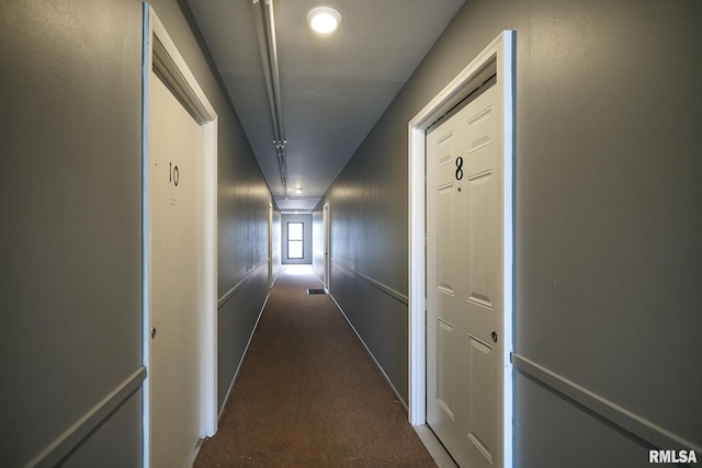 corridor featuring dark carpet