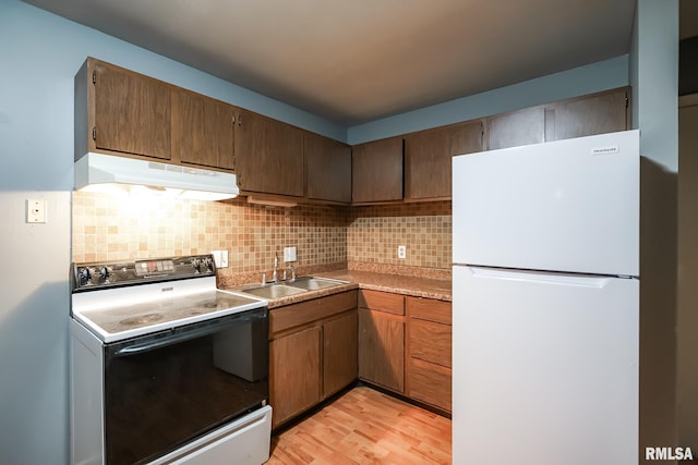 kitchen featuring sink, white appliances, decorative backsplash, and light wood-type flooring