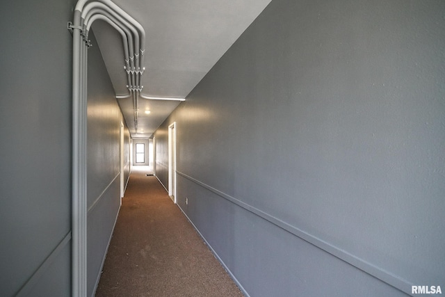 corridor featuring dark colored carpet