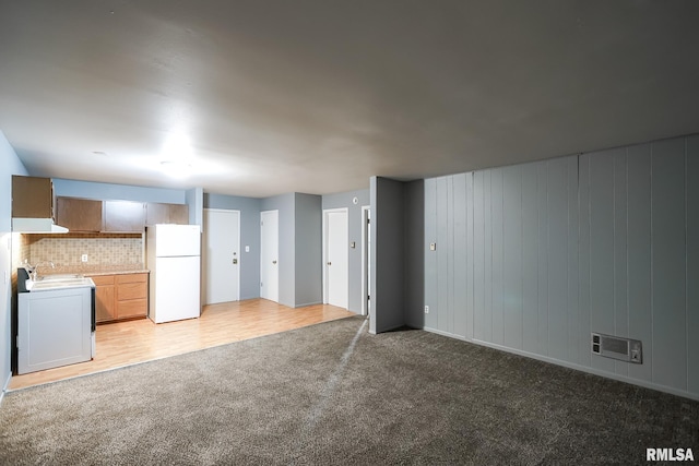 unfurnished living room featuring sink and light colored carpet