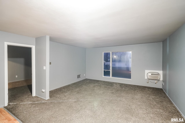 unfurnished room with a wall mounted AC and carpet