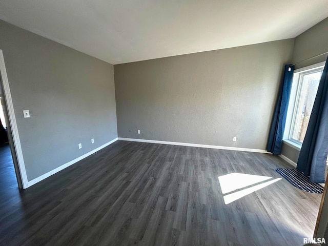 spare room featuring dark wood-type flooring