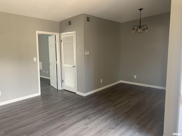 unfurnished room with dark hardwood / wood-style floors and a chandelier