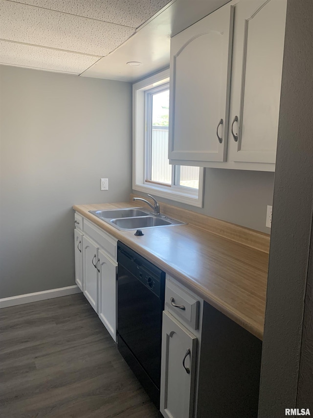 kitchen featuring sink, white cabinetry, black dishwasher, a drop ceiling, and dark hardwood / wood-style flooring