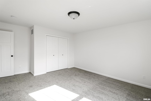 unfurnished bedroom featuring a closet and carpet flooring