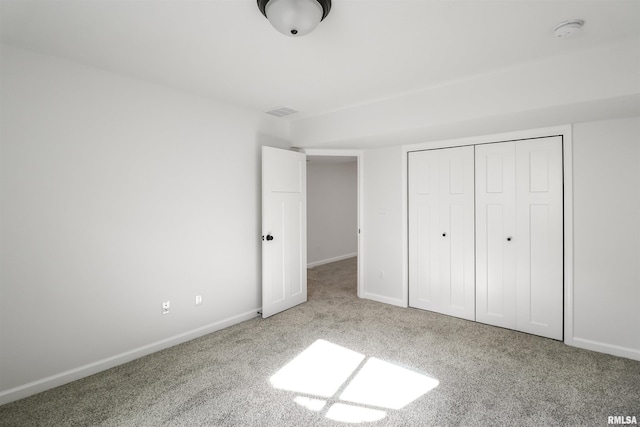 unfurnished bedroom featuring light colored carpet and a closet