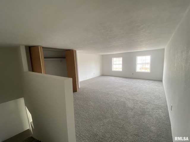 carpeted empty room with a textured ceiling