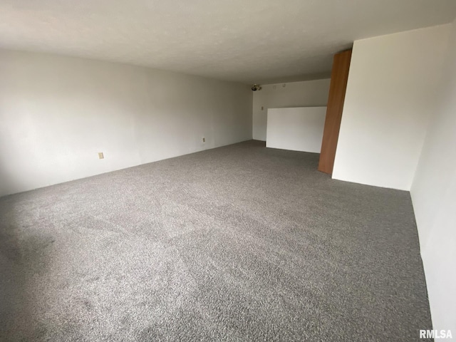 unfurnished room featuring dark carpet