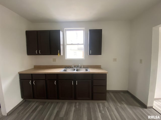 kitchen featuring dark brown cabinetry, sink, and hardwood / wood-style flooring