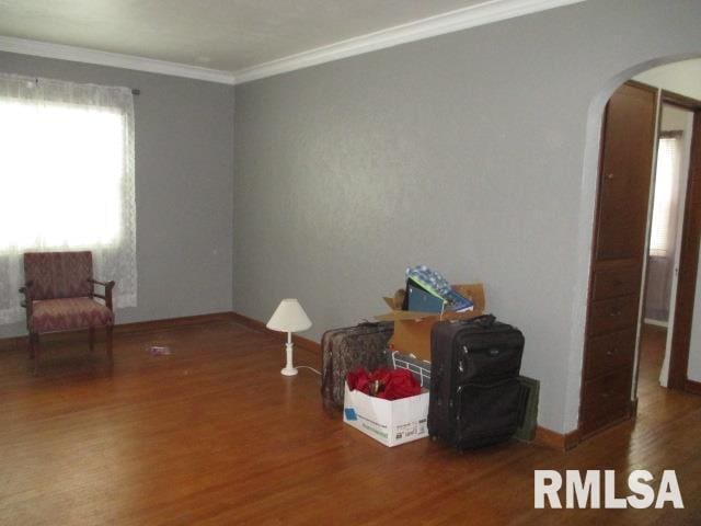 interior space with crown molding and dark wood-type flooring