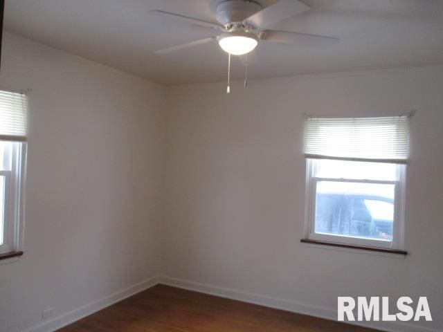 spare room with dark hardwood / wood-style flooring and ceiling fan