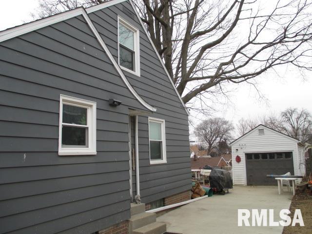 view of side of home featuring a garage and an outbuilding