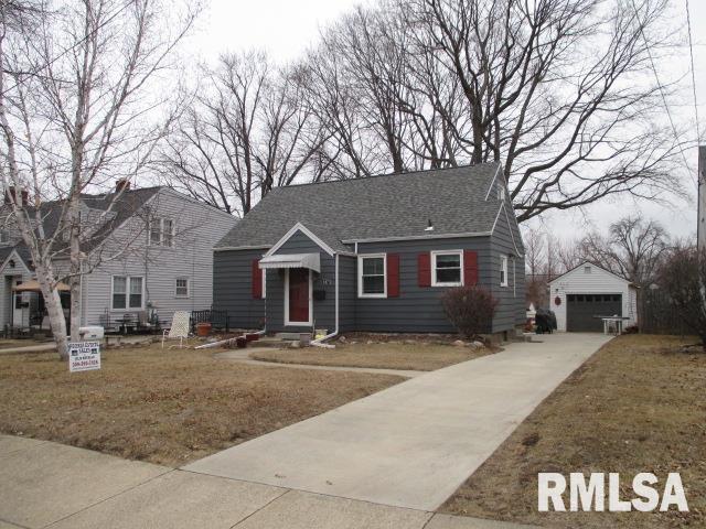 view of front of house with an outbuilding, a garage, and a front lawn