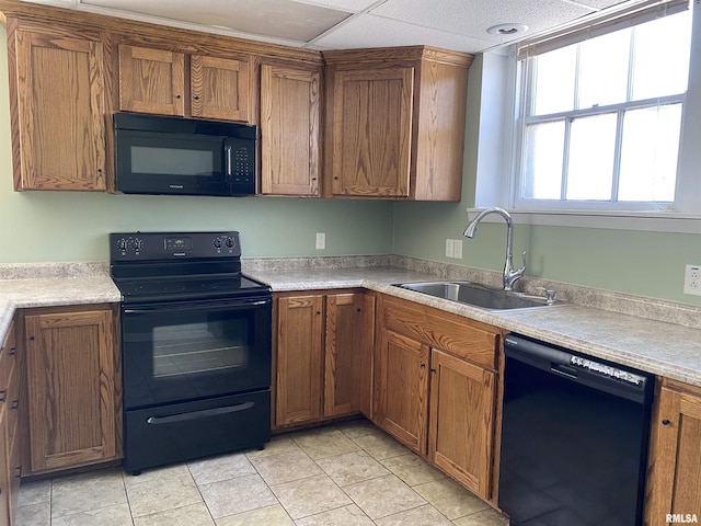 kitchen featuring light tile patterned flooring, sink, and black appliances