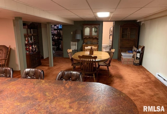 dining area featuring a baseboard radiator, carpet, and a drop ceiling