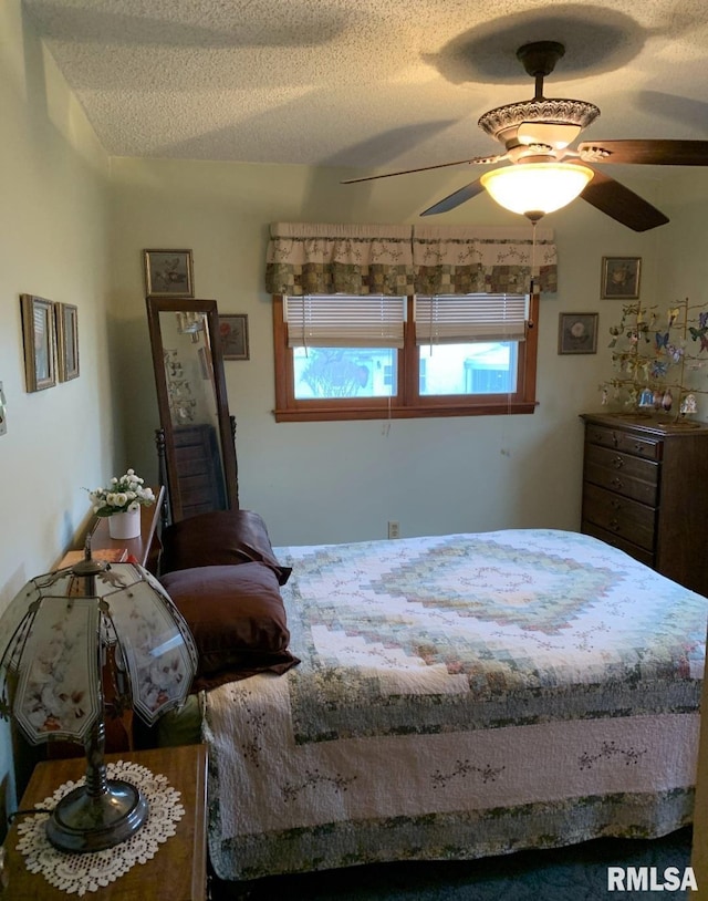 bedroom with ceiling fan and a textured ceiling