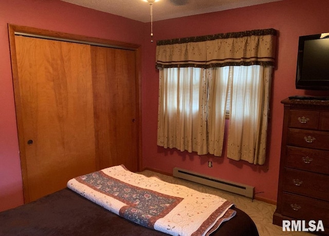 bedroom featuring baseboard heating and a closet