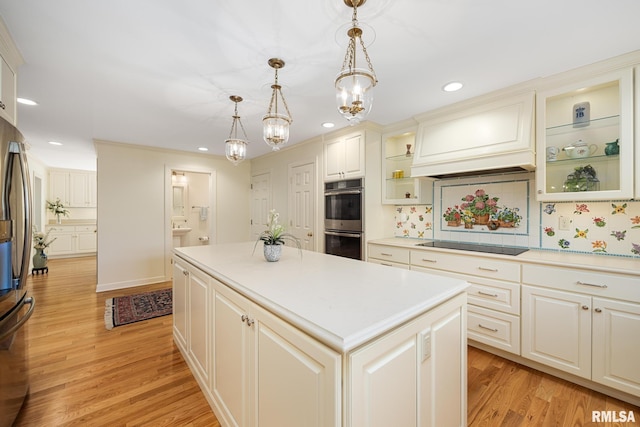 kitchen featuring pendant lighting, appliances with stainless steel finishes, light hardwood / wood-style floors, and a kitchen island