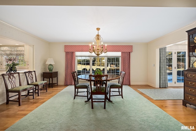 dining room featuring hardwood / wood-style flooring, ornamental molding, and a notable chandelier