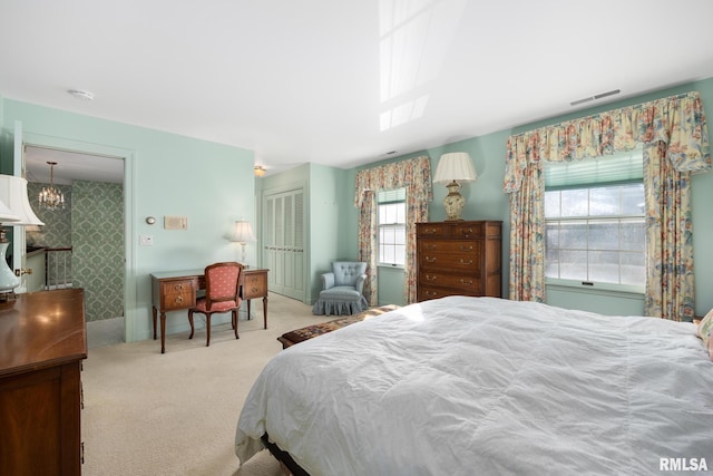 bedroom featuring light carpet, a closet, and a chandelier