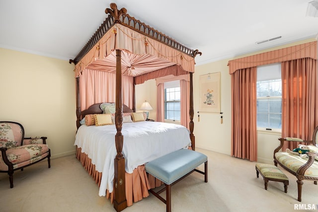 bedroom with ornamental molding and light colored carpet